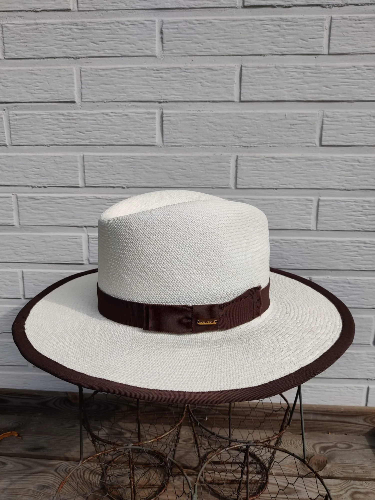 Witte panamahoed met bruin grosgrainlint en bruin afgebiesde rand