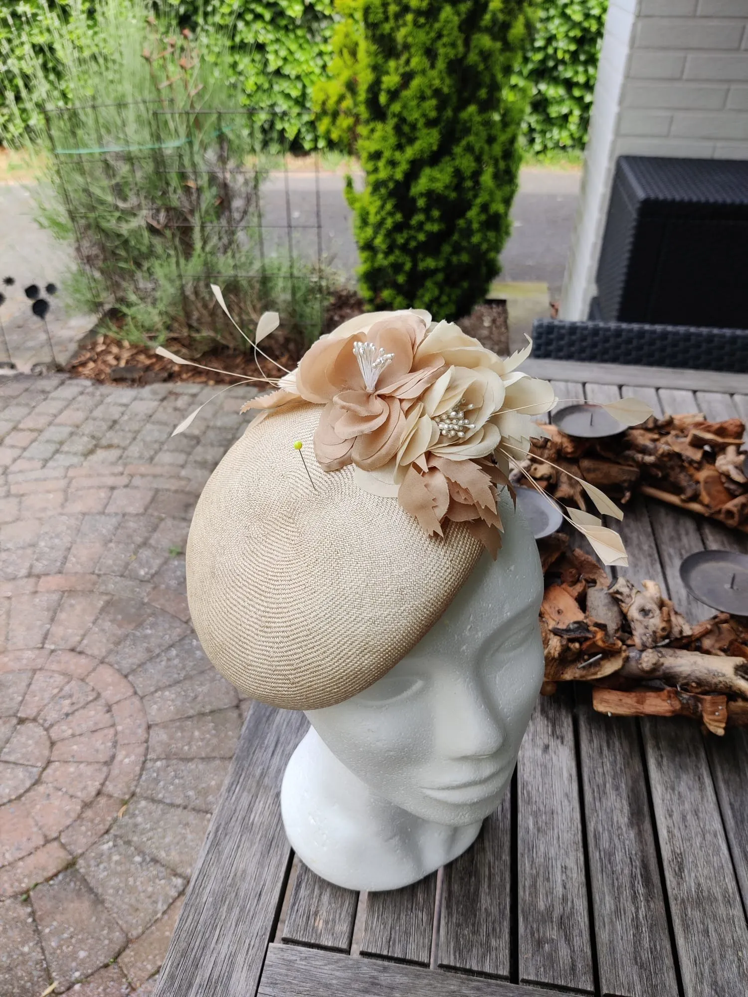 Beige schotelhoedje met zijden bloemen, blaadjes en parelhartjes